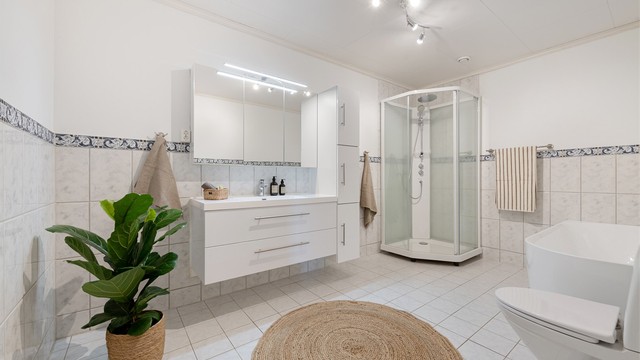 Badet i underetasjen er romslig og utstyrt med både badekar og dusjkabinett.