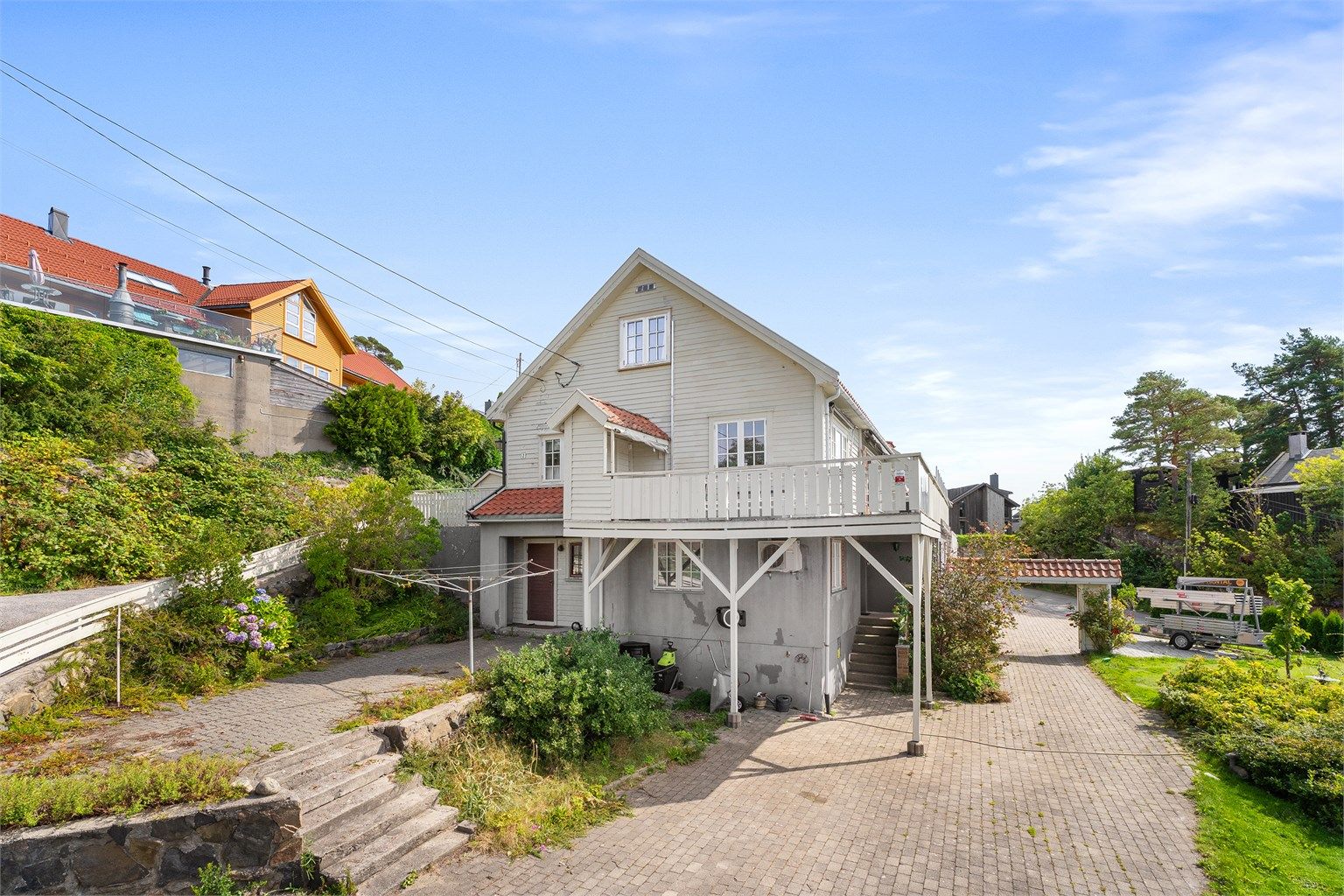 Romslig tomt med flere solrike uteområder. Opparbeidet med belegningsstein, naturmurer, gressplen, hekk og beplantninger