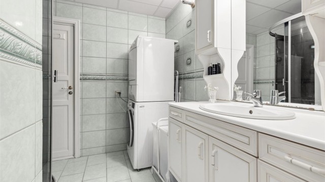 Badet har flislagt gulv og vegger, og er innredet med servantinnredning og dusjkabinett.