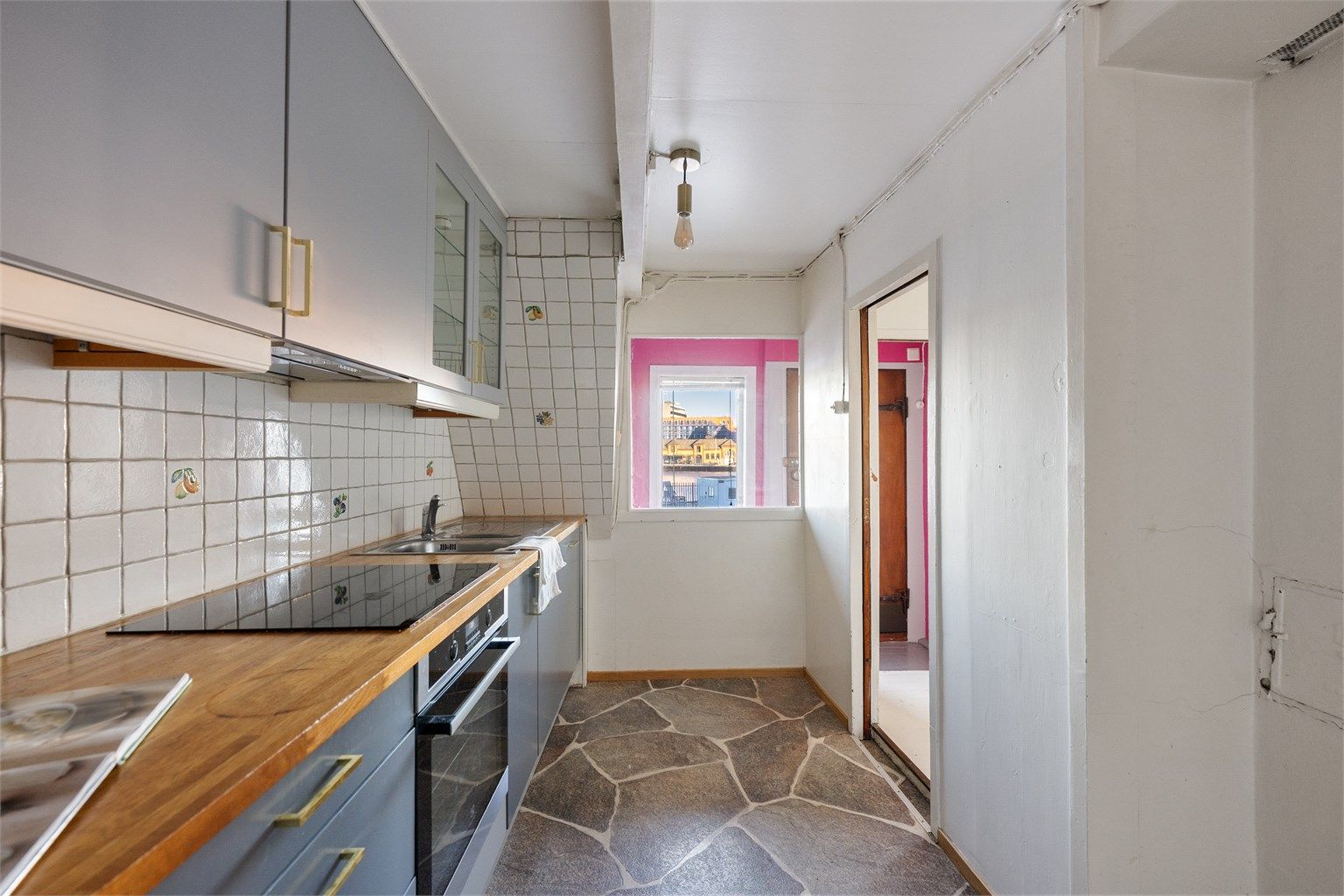 Det er belegg på gulv. Kjøkkeninnredning er et gammelt IKEA med epoq fronter.