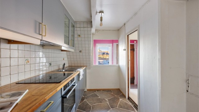 Det er belegg på gulv. Kjøkkeninnredning er et gammelt IKEA med epoq fronter.