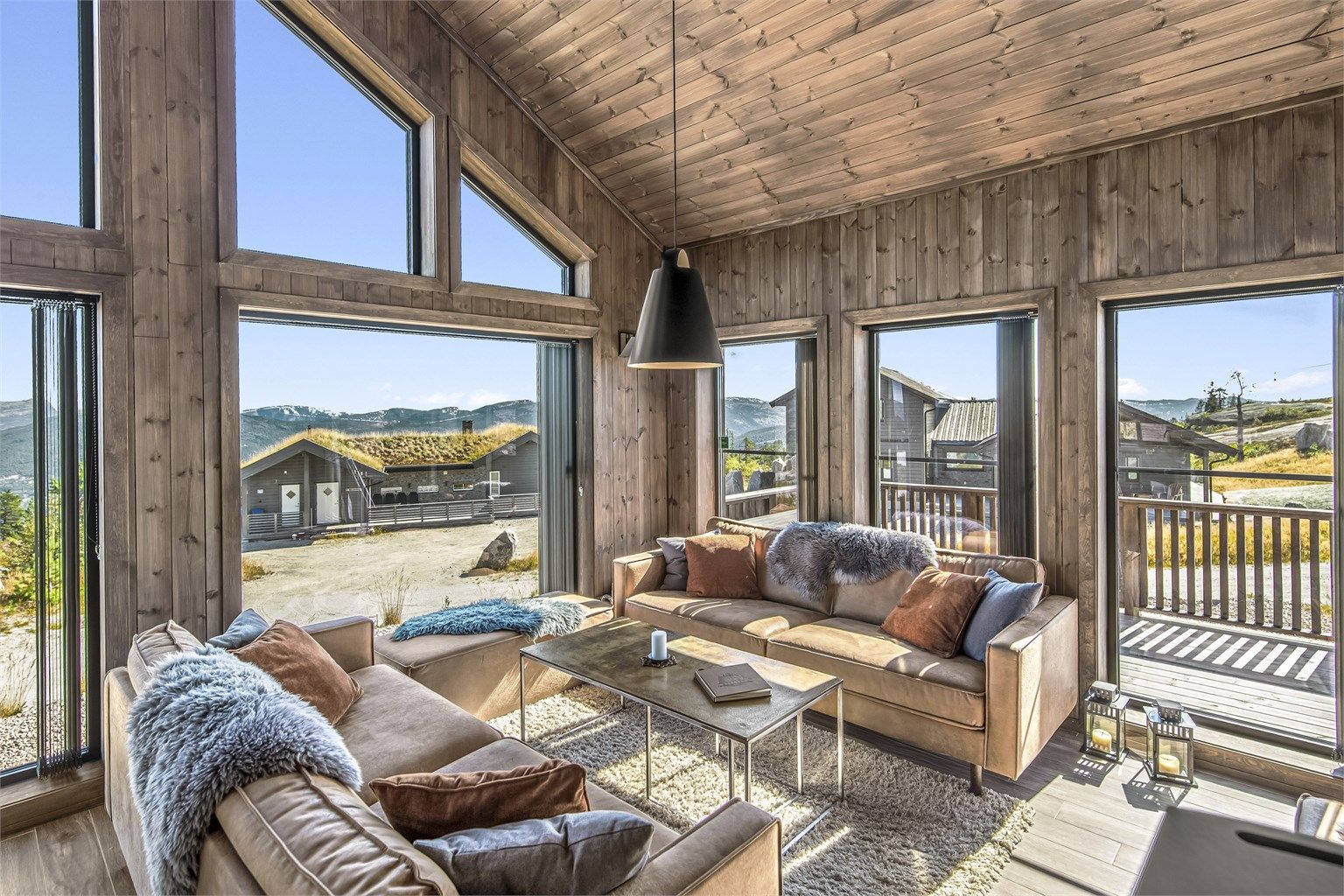 Den svarte pendellampen er fra Louis Poulsen, Above-pendel. Et flott smykke over sofa-gruppen.