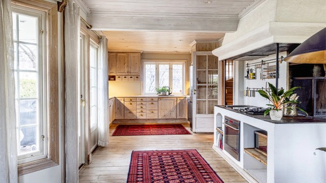 Kjøkkenets skap- og benkeinnredning er i heltre og håndlaget av møbelsnekker for nettopp denne boligen.