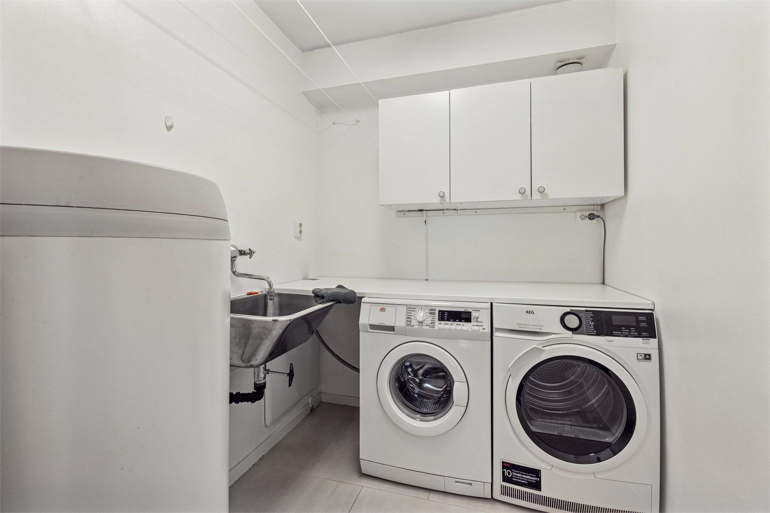 Praktisk vaskerom med skyllekum og opplegg for vaskemaskin og tørketrommel.