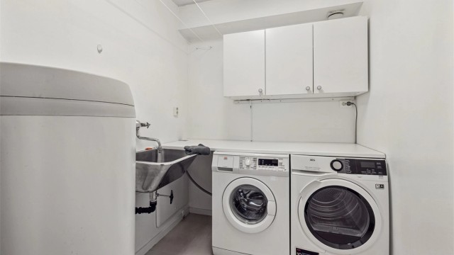 Praktisk vaskerom med skyllekum og opplegg for vaskemaskin og tørketrommel.