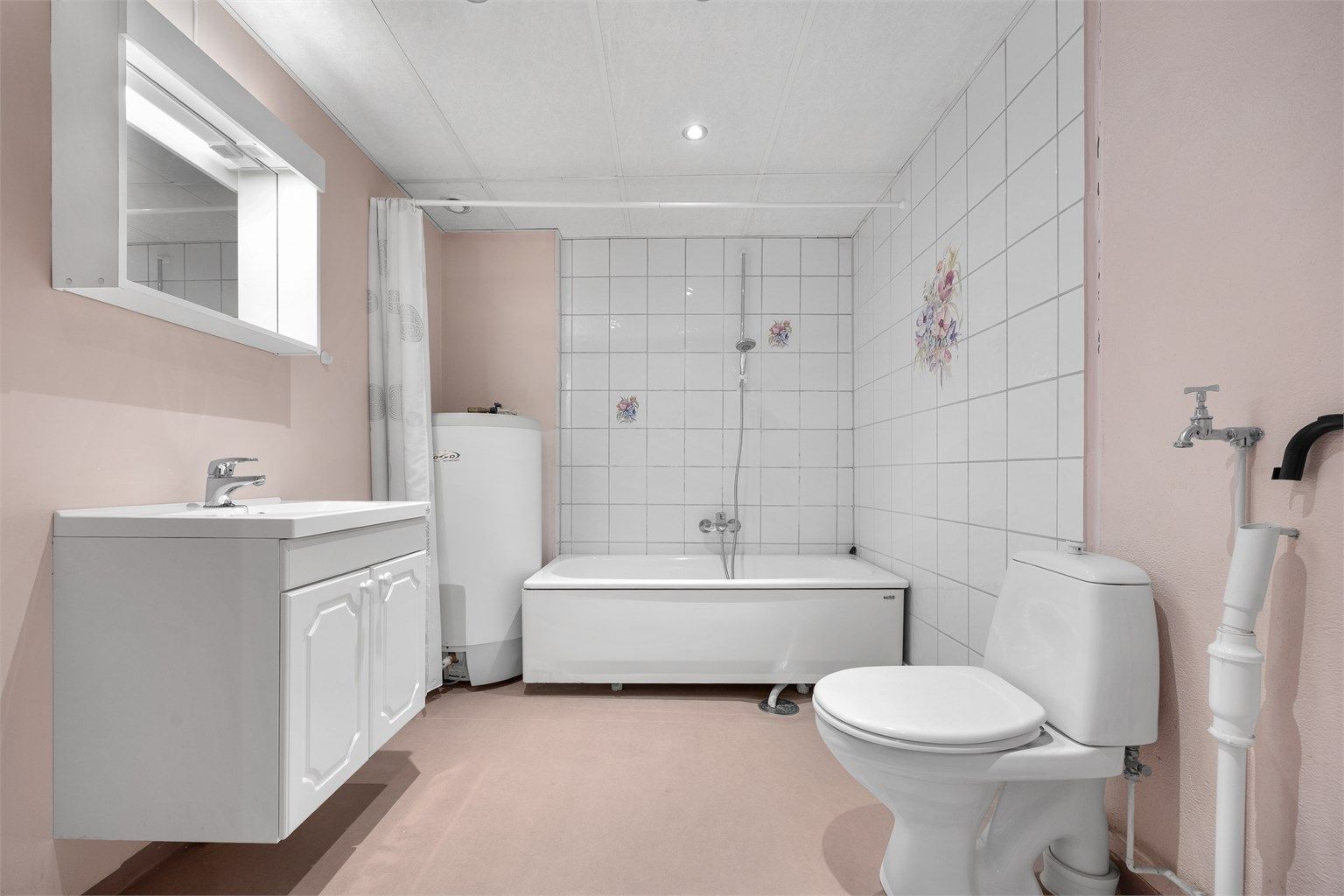 Badet er utstyrt med badekar og har opplegg for vaskemaskin.