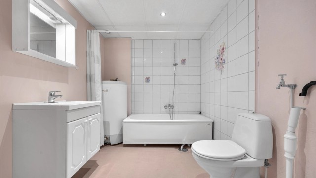 Badet er utstyrt med badekar og har opplegg for vaskemaskin.
