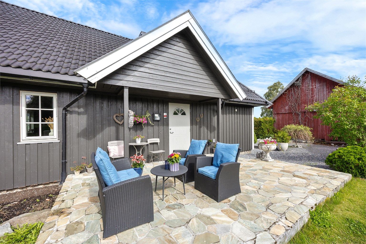 Steinbelagt uteplass med plass til en liten sittegruppe.