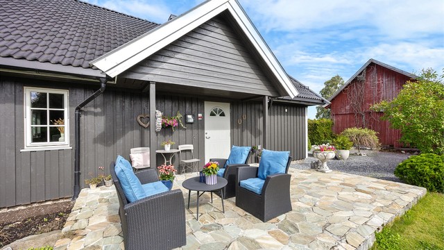Steinbelagt uteplass med plass til en liten sittegruppe.