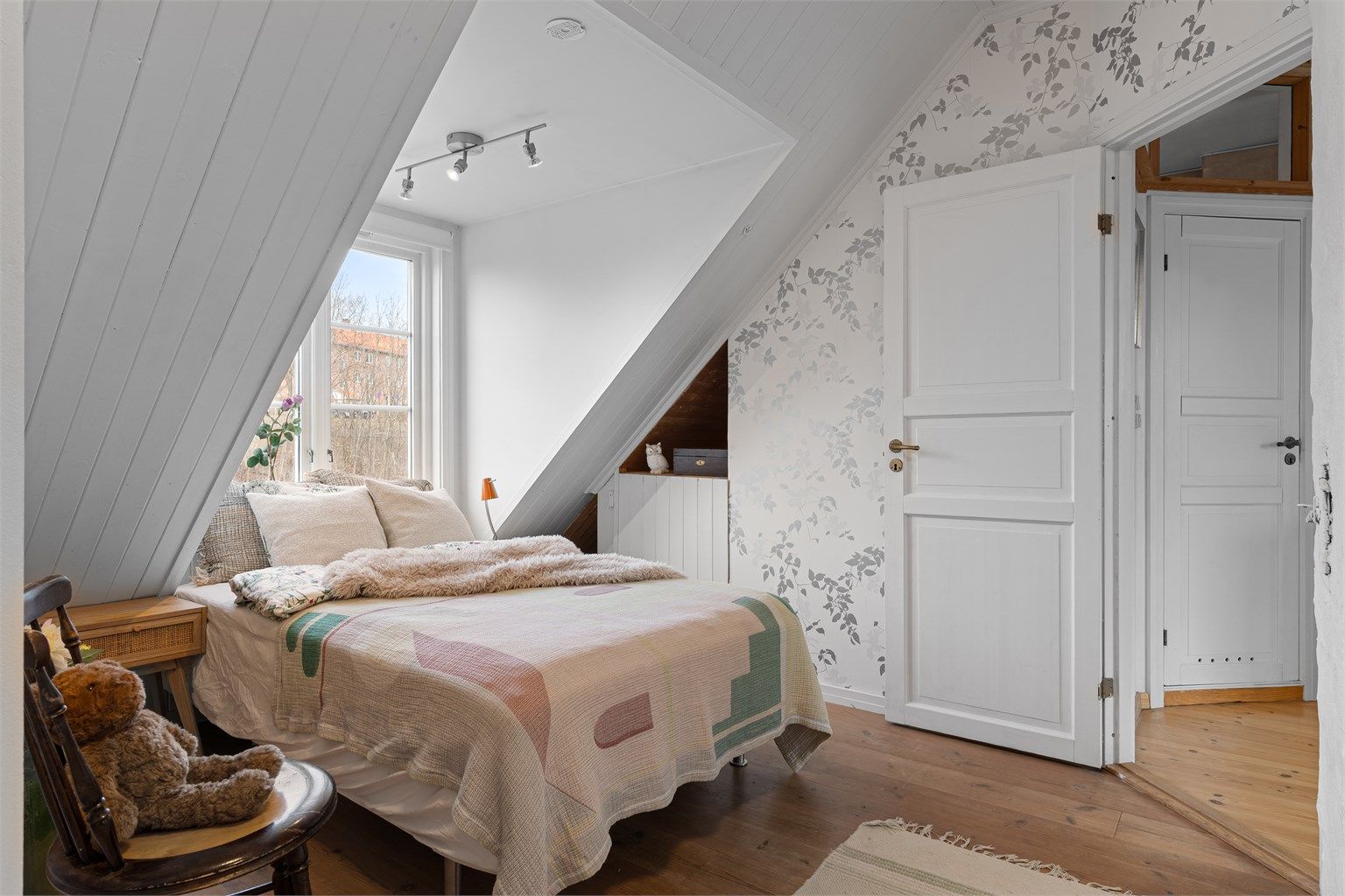 Malte fyllingsdører og en fondvegg med tapet gir rommet et personlig preg.