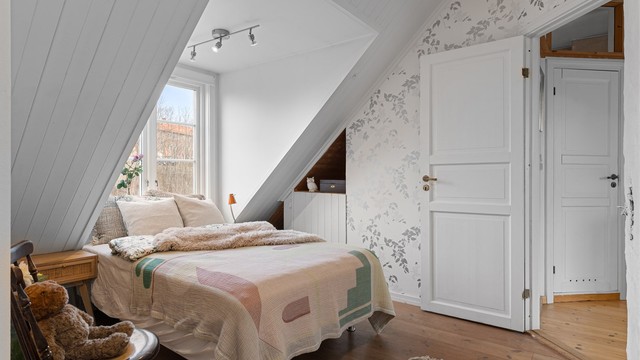 Malte fyllingsdører og en fondvegg med tapet gir rommet et personlig preg.