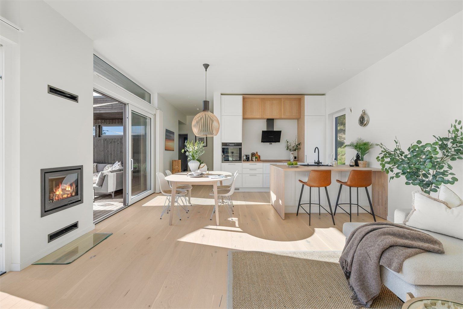 En innbygget peisovn skaper en lun stemning i stue- og kjøkkensonen.