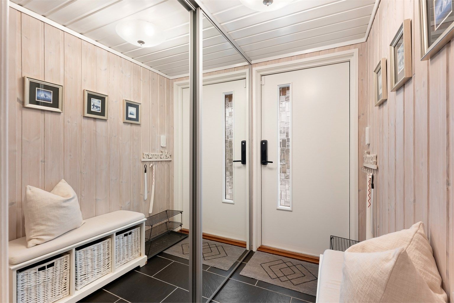 Entréen har flislagt gulv og god oppbevaringsplass i en skyvedørsgarderobe.