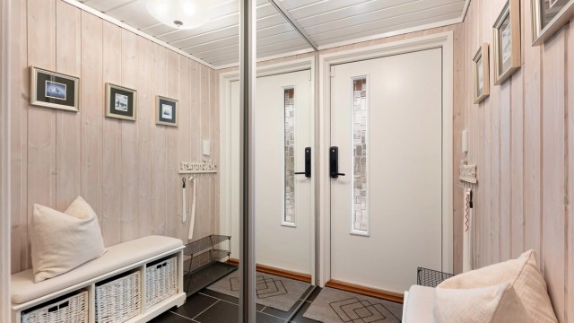 Entréen har flislagt gulv og god oppbevaringsplass i en skyvedørsgarderobe.
