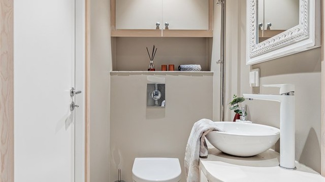 Badet i 1.etasje har flislagt gulv med gulvvarme og vegghengt toalett.