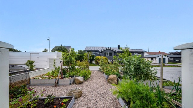 Lettstelt grønnsakshage med singelganger og godt lokalt klima for både planter og uteliv.