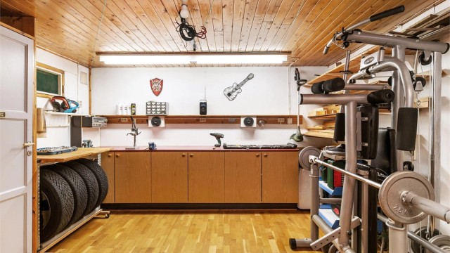 Stor bod i underetasjen tilrettelagt som verksted og hobbyrom med arbeidsbenk.