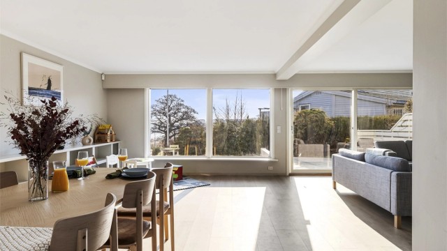 Vindusrekken mot hagen og sjøen slipper naturen inn.