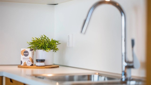 Kjøkkenet har innredning med glatte fronter, benkeplaten er av laminat.