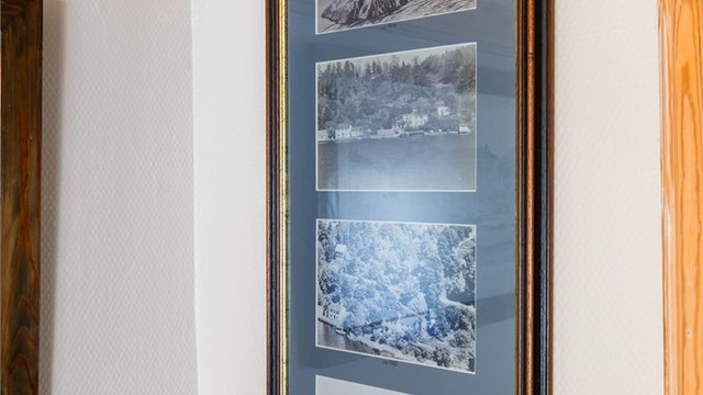Historiske bilder av eiendommen pryder veggene og forteller en historie.