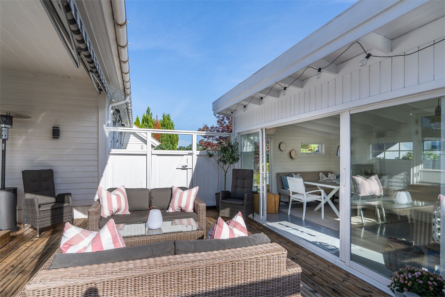 Treterrassen danner et lunt og skjermet uterom mellom huset og utestuen.