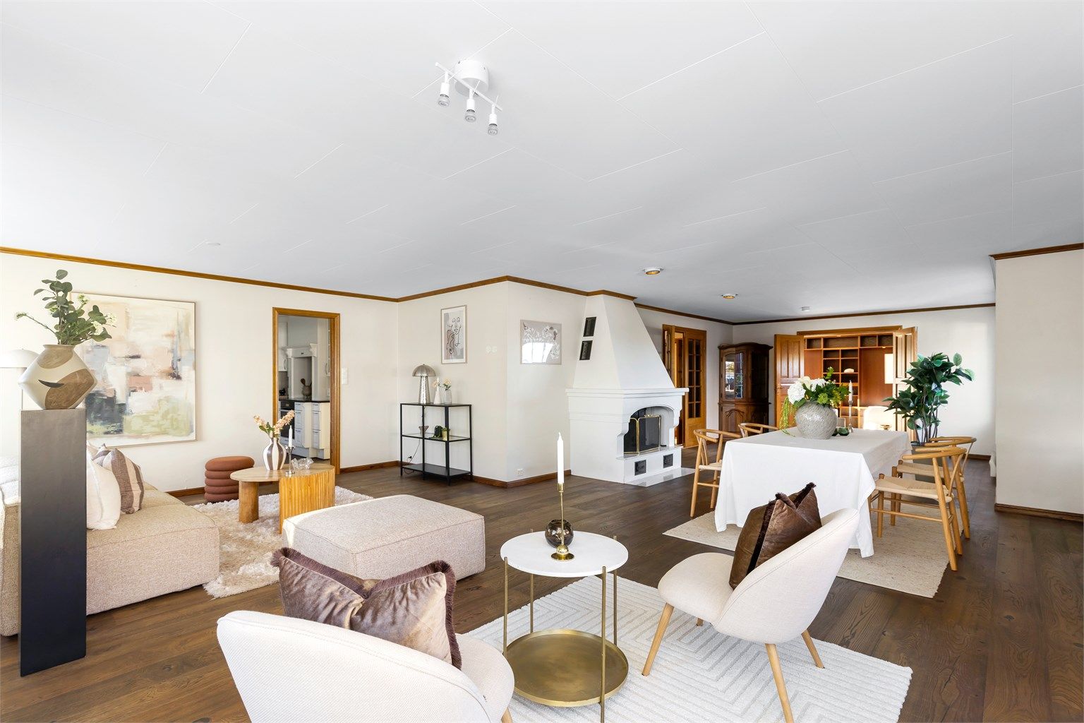 Boligen har en romslig vinkelstue med åpen peis, store vinduer og god plass til langbord.
Foto: Marianne Lyse