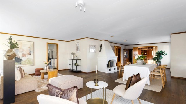 Boligen har en romslig vinkelstue med åpen peis, store vinduer og god plass til langbord.
Foto: Marianne Lyse