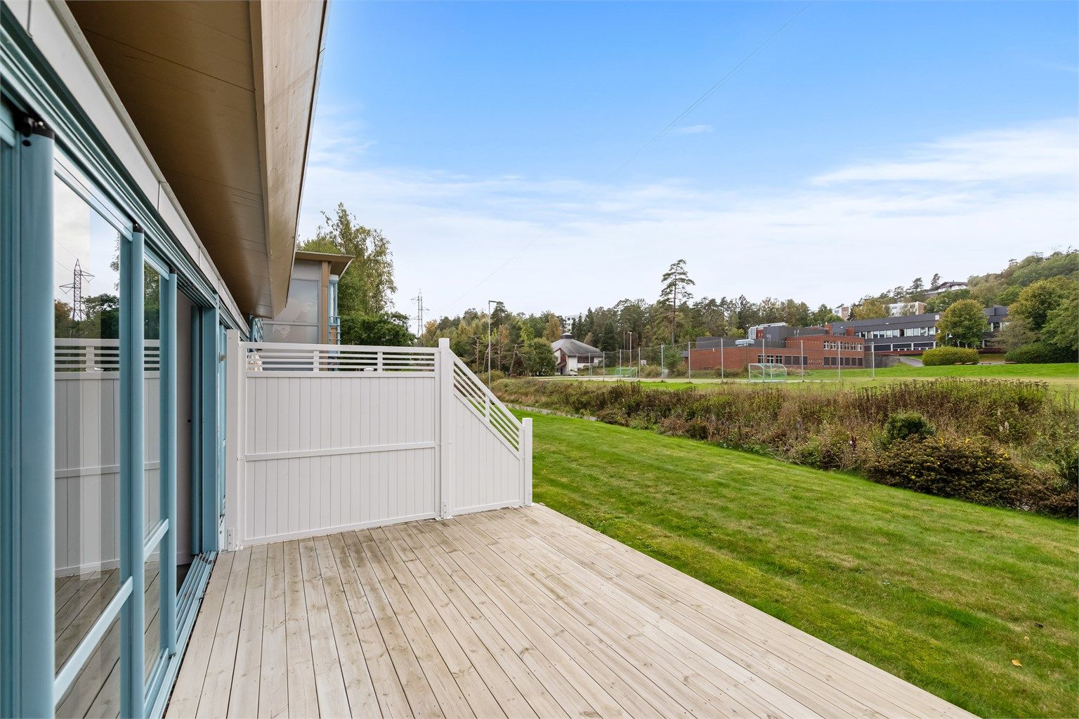 Uteplassen grenser mot store grøntarealer med Varden ungdomsskole i bakgrunnen.