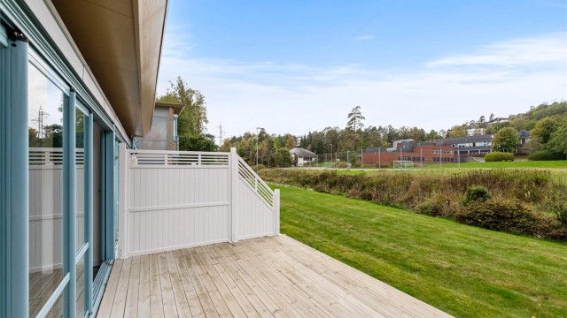 Uteplassen grenser mot store grøntarealer med Varden ungdomsskole i bakgrunnen.