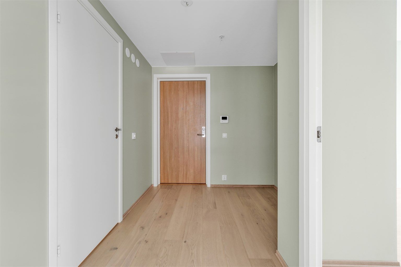 Innbydende og lys entré. Garderobeskap med plass til tøy og diverse. Ytterligere plass til oppheng av tøy og oppbevaring av sko eller for eksempel puff. Callinganlegg med video plassert på vegg. Flott eikeparkett på gulv