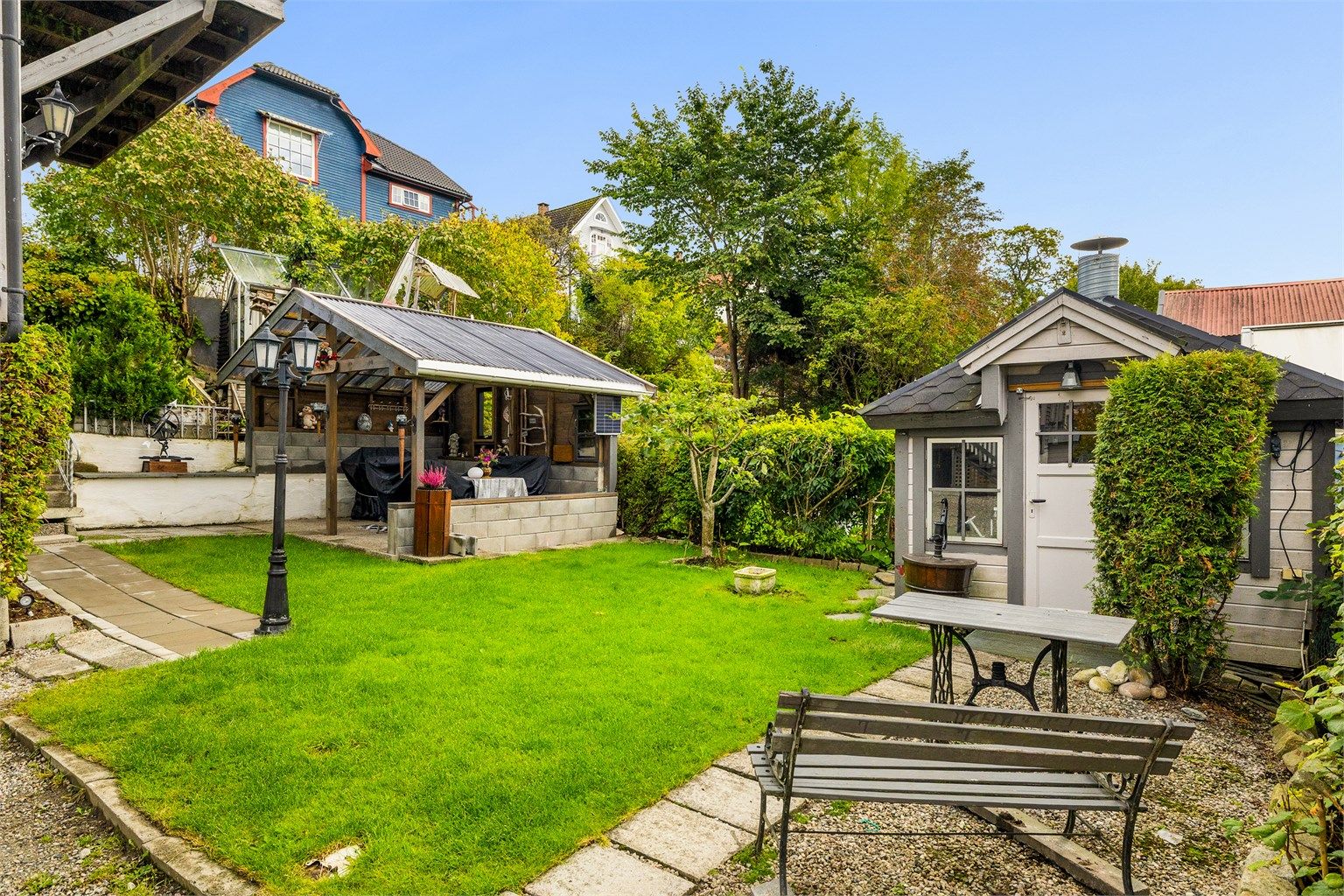 Flotte uteområder med hage, grillhytte og overbygget platting.