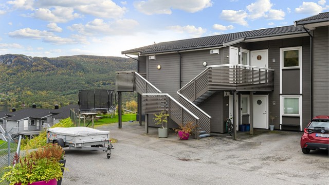 Leiligheten har adkomst via trapp, og i tilknytning til bygget finnes et trivelig felles uteområde med gressplen og plass til lek og aktivitet.