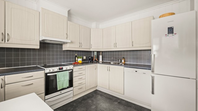 Kjøkkeninnredning med profilerte fronter og laminatbenkeplate. Komfyr og kombiskap medfølger handelen.