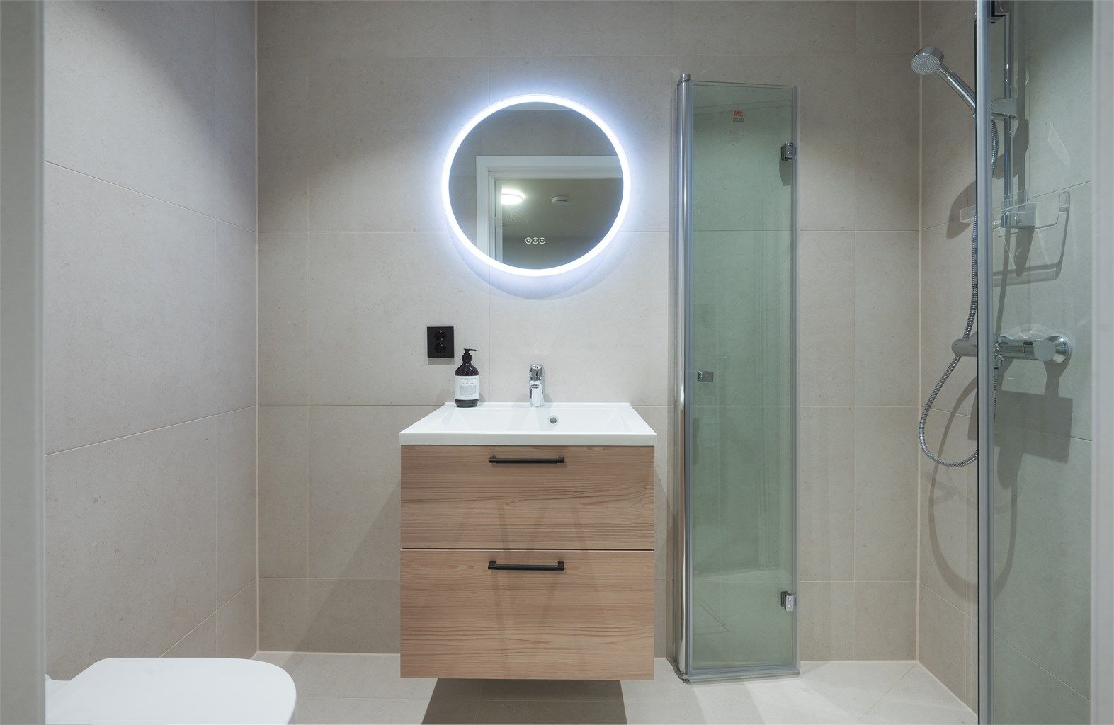 Badet i underetasjen har matte fliser, dusjhjørne, opplegg for vaskemaskin og gulvvarme.