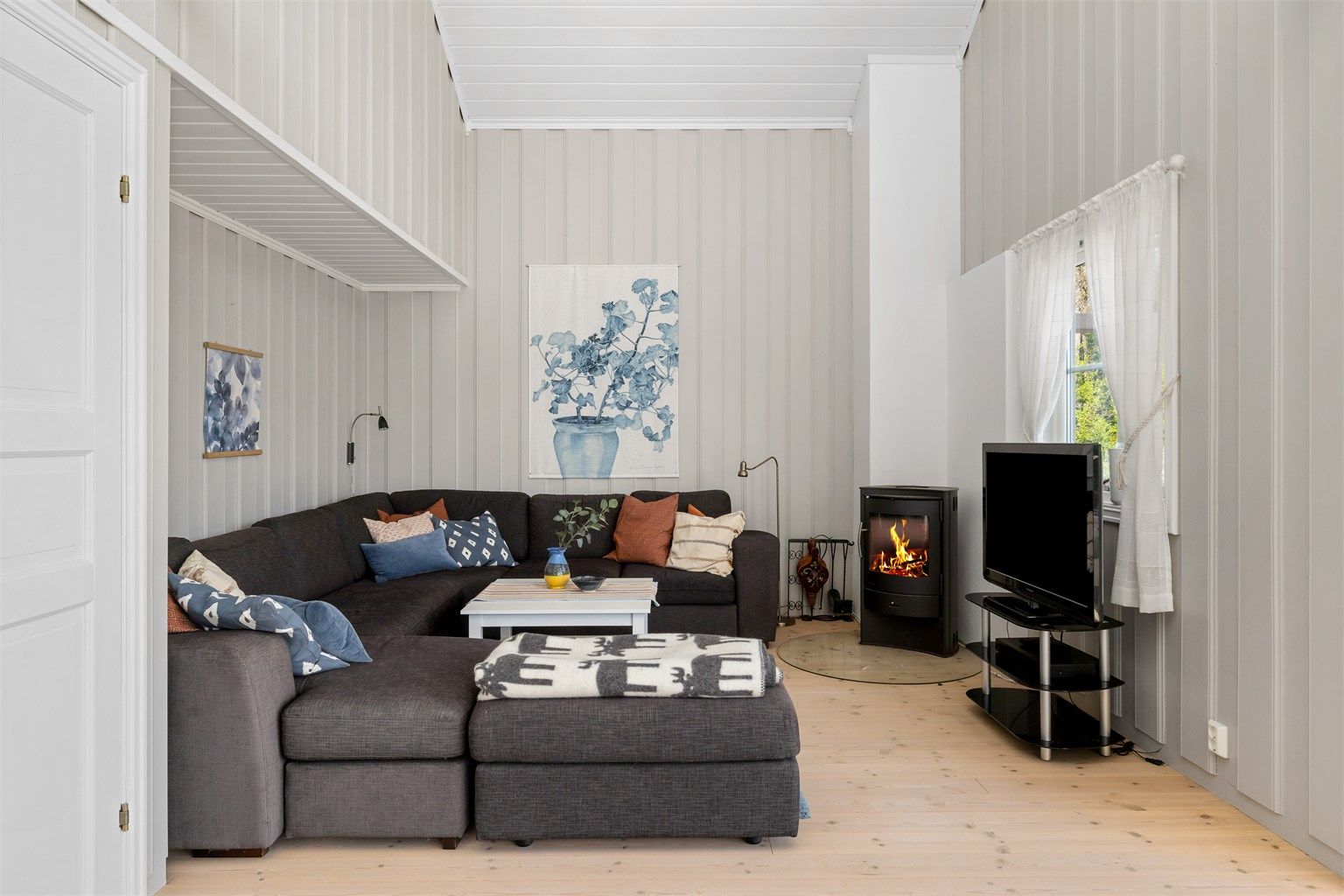 Stuen har god plass til både sofa og lesekrok, takhøyden på ca. 5 meter sørger for en god romfølelse.