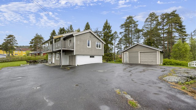 Enebolig med stor tomt, integrert garasje og en separat garasjebygning på 32 m² med verksted.