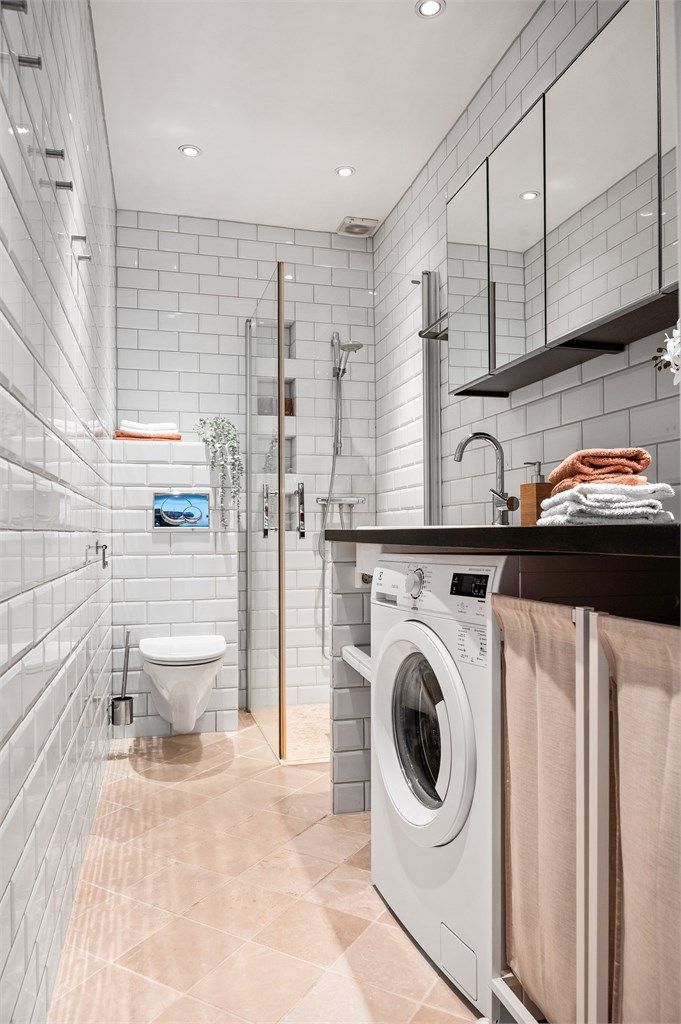 Badet er innredet med benkeplate av tre med nedfelt servant av porselen, vegghengte skap med speil over servant og dusjhjørne med innfellbare glassdører.