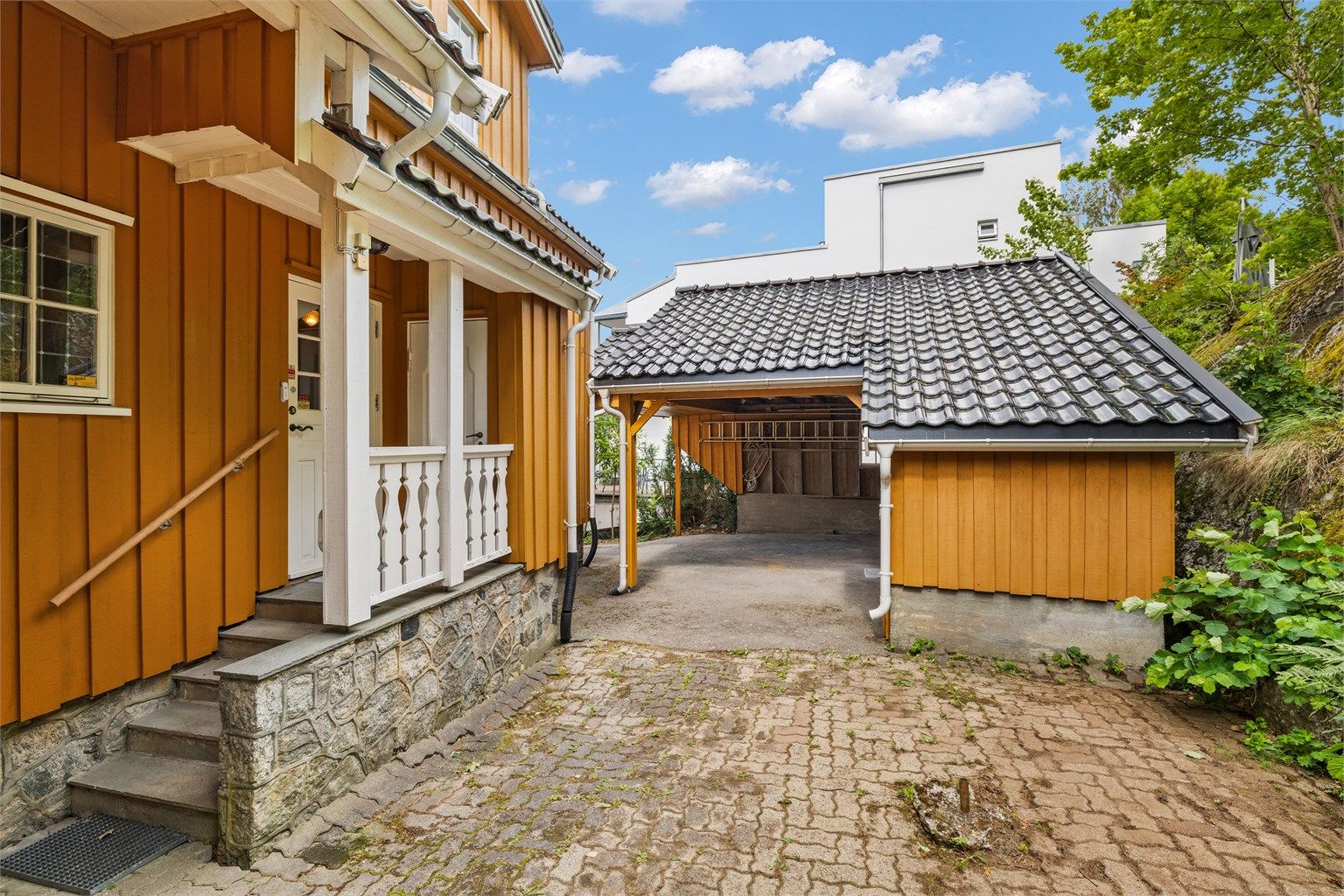 Bilen parkeres i eller utenfor en carport med tilhørende bod på ca. 7 kvm.