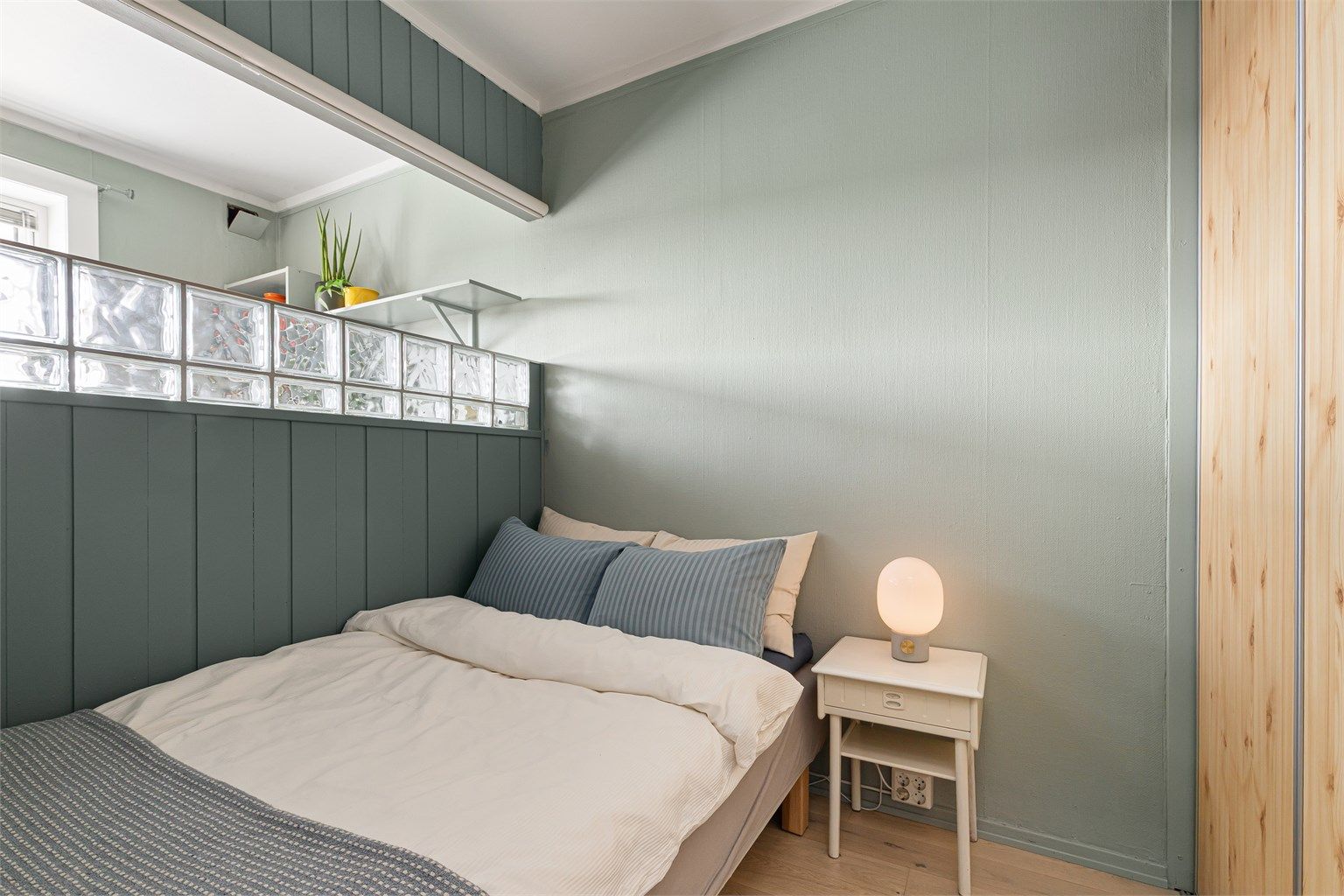 I tillegg til seng og nattbord er det også en skyvedørsgarderobe for klesoppbevaring og et overskap med rom til ekstra lagring