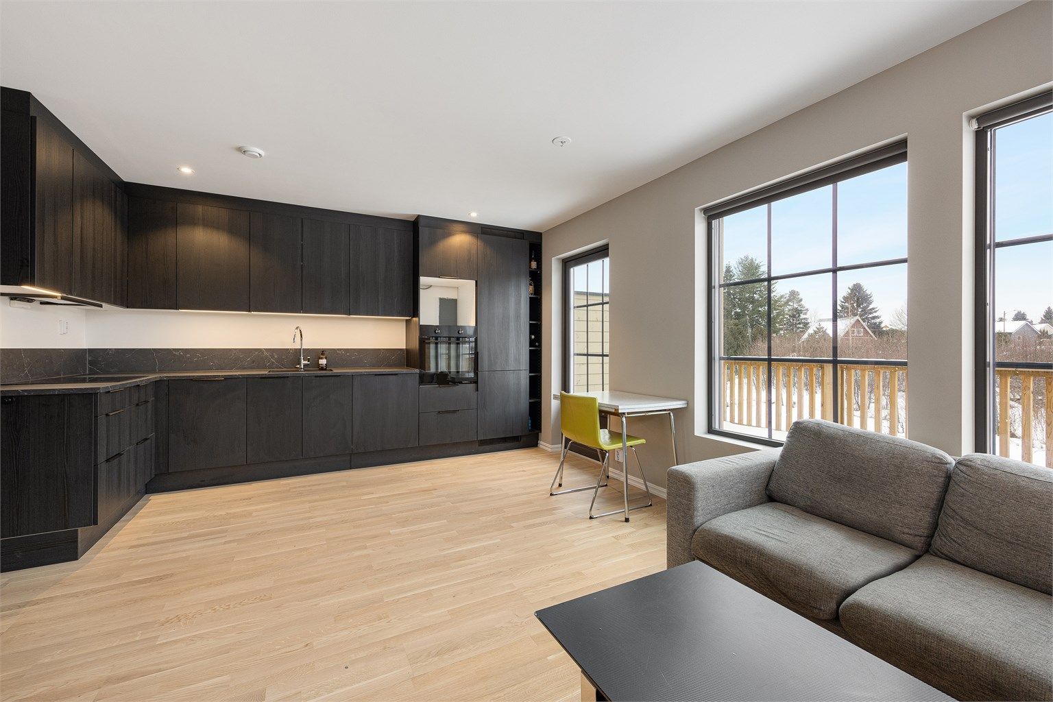 Store vindusflater og downlights i taket gir gode lysforhold i hele rommet.