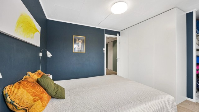 En stor garderobe med glatte fronter gir rikelig med oppbevaringsplass.