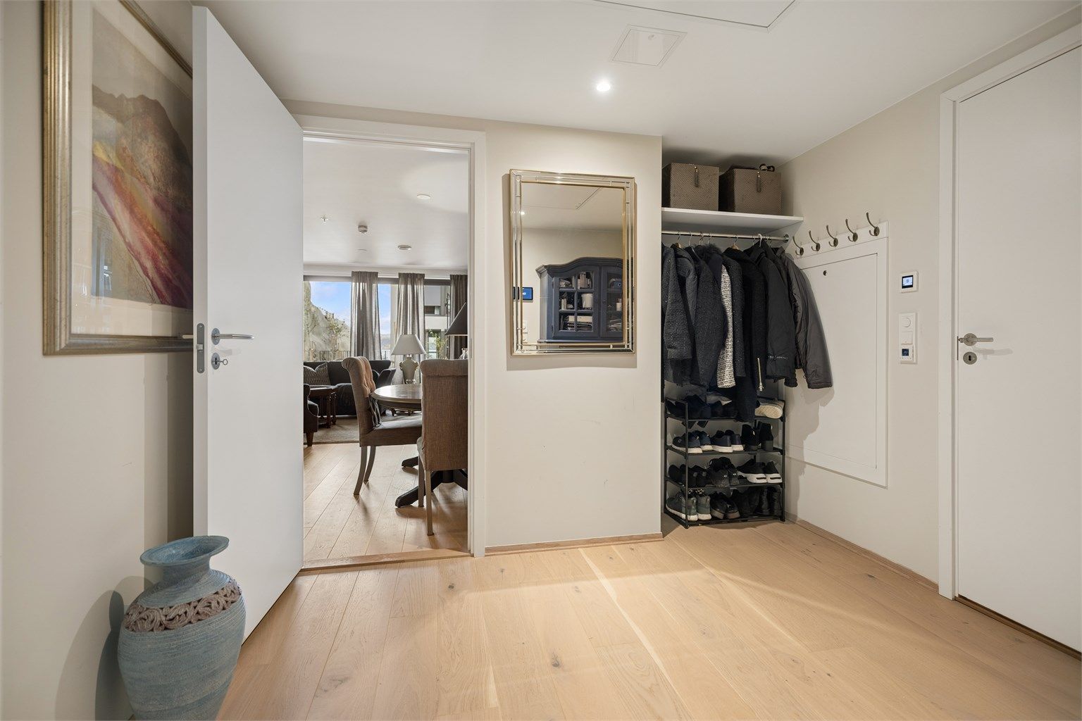 Velkommen inn! Entréen har downlights i himling, vannbåren gulvvarme og åpen sikt inn mot stuen.