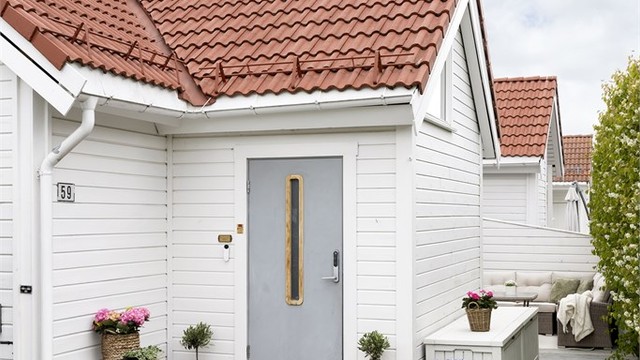 Pent opparbeidet tomt med stenlagt innkjørsel, flere terrasser og gressplen