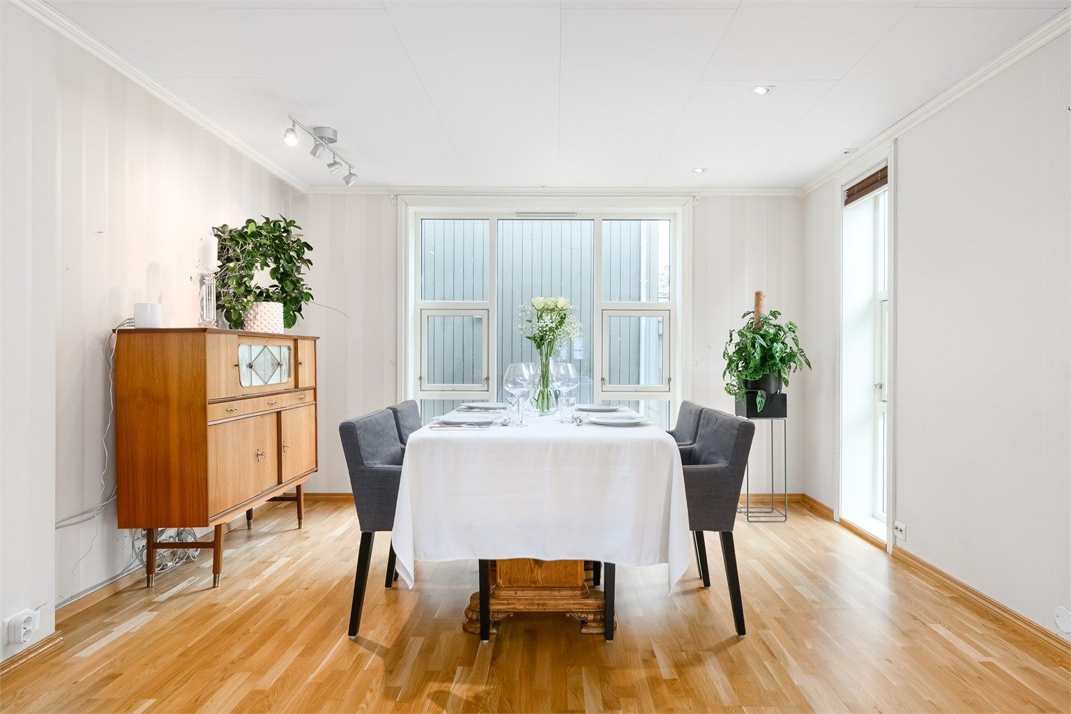 Spisestue med store vinduer som gir en lys og luftig atmosfære