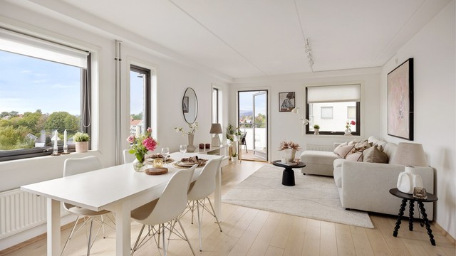 Lys og fin stue med plass til stort spisebord og sittegruppe med utgang til balkong