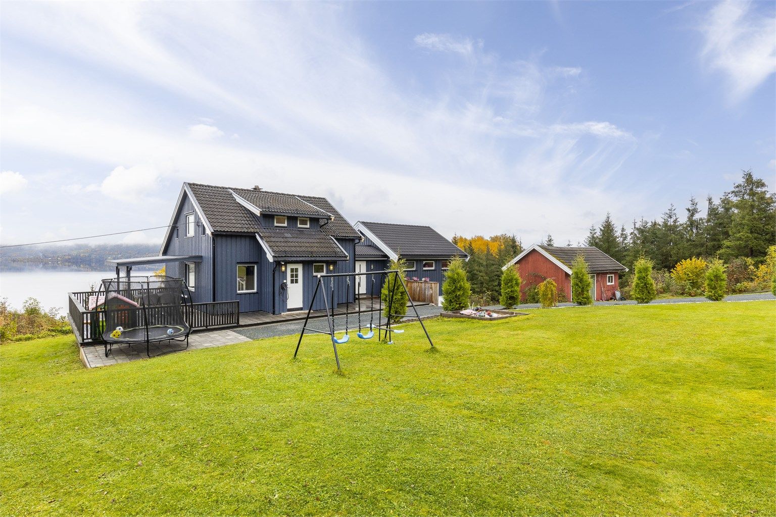 Pent opparbeidet tomt med plenarealer, thujahekk og fine uteplasser