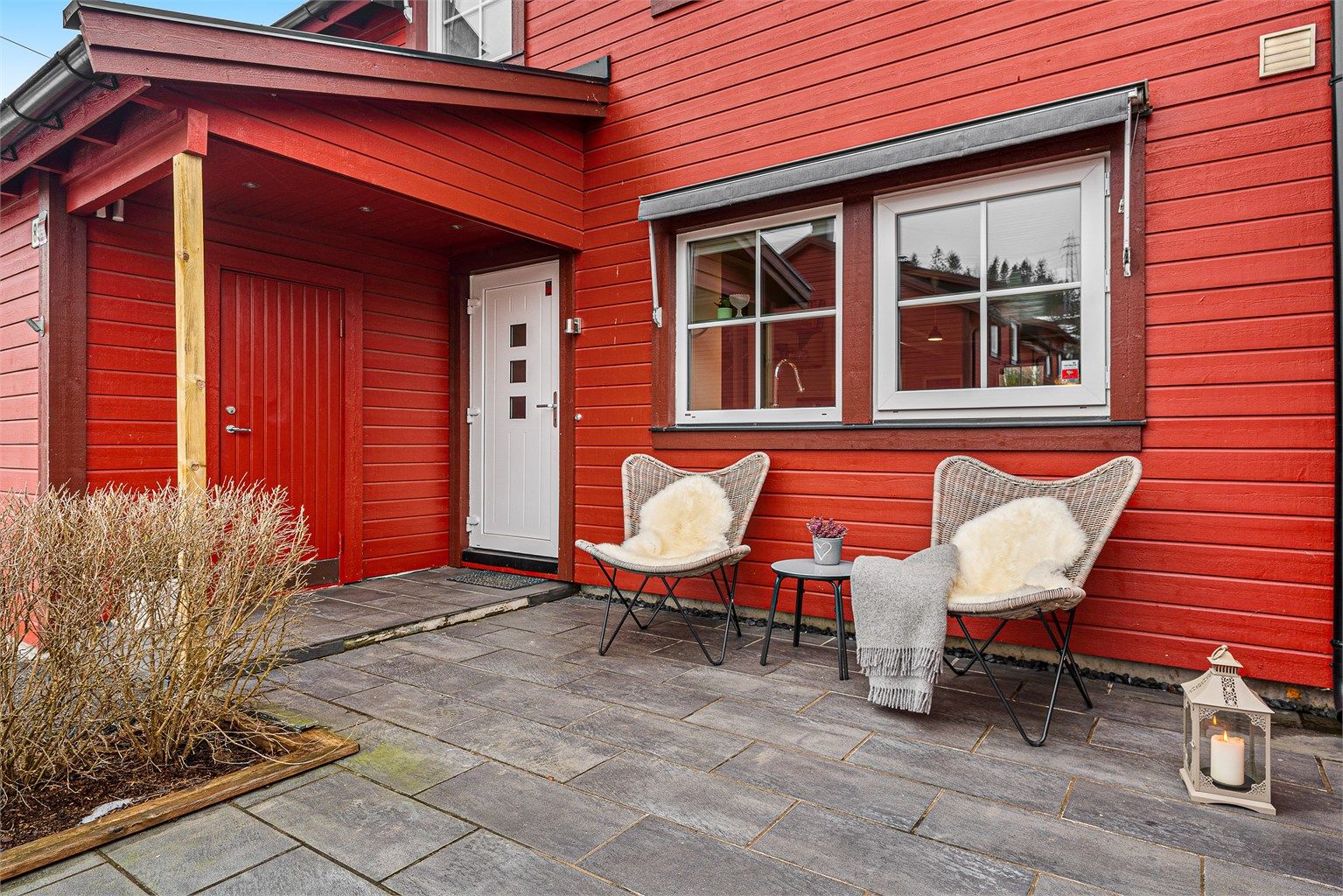 En hyggelig og steinbelagt adkomstterrasse ved inngangspartiet.