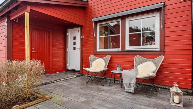 En hyggelig og steinbelagt adkomstterrasse ved inngangspartiet.