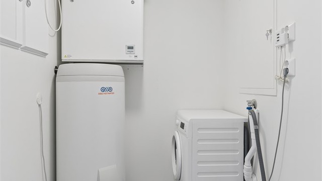 Praktisk innvendig bod med sluk i gulvet, med varmtvannsbereder, ventilasjonsaggregat og opplegg for vaskemaskin og tørketrommel. Det separate rommet gir en funksjonell og ryddig løsning i hverdagen, med god arbeidsplass og mulighet til å tørke tøy.