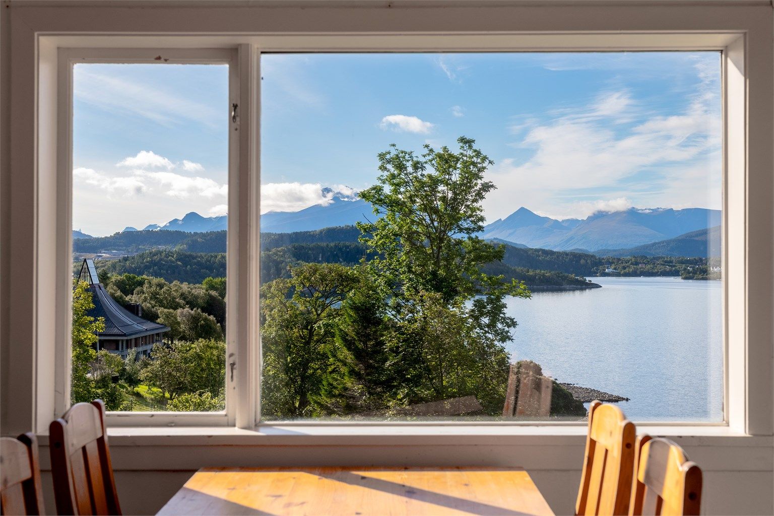 Fra vinduet er det utsyn mot Ellingsøy kirke og fjordlandskapet.